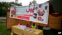 FILE - A worker sits in stall set up by the charity Falah-e-Insaniat Foundation, waiting for donations for Indian Kashmiris, in Islamabad, Pakistan, Aug. 2, 2016. FIF is a U.S.- and U.N.-designated terror group.