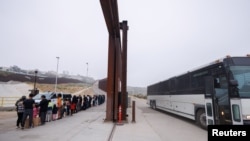 Agentes de la Patrulla Fronteriza de EEUU abren una gran puerta y traen un autobús para transportar a los migrantes que durante la noche se reunieron entre los muros fronterizos primario y secundario que separan a México y Estados Unidos, el 6 de junio de 2024. 