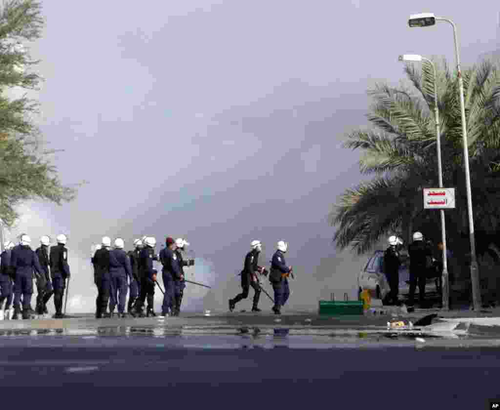 Riot police firing tear gas pursue Bahraini anti-government protesters in Sanabis, on the edge of the capital of Manama. (AP)