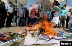 Palestinians burn pictures during a protest against the United Arab Emirates and Bahrain's deal with Israel to normalize relations, in Gaza City, Sept. 15, 2020.
