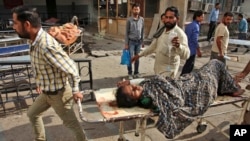 An Indian woman is brought to a government medical college hospital after she was injured in firing by Pakistani troops across the India-Pakistan border at Jora farm in Ranbir Singh Pura, in Jammu, India, Oct. 8, 2014. 