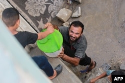 Displaced Palestinians queue for water in Khan Yunis, in the southern Gaza Strip, on July 30, 2024.