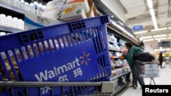 FILE - A shopping cart full of products is seen as a customer shops at a Wal-Mart store in Beijing.