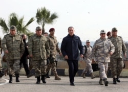 Turkey's National Defence Minister Hulusi Akar, center, and Turkish army's top commanders arrive to inspect troops at the border with Syria, in Hatay, Turkey, Feb. 3, 2020.