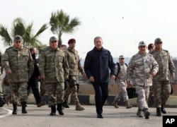 Turkey's National Defence Minister Hulusi Akar, center, and Turkish army's top commanders arrive to inspect troops at the border with Syria, in Hatay, Turkey, Feb. 3, 2020.
