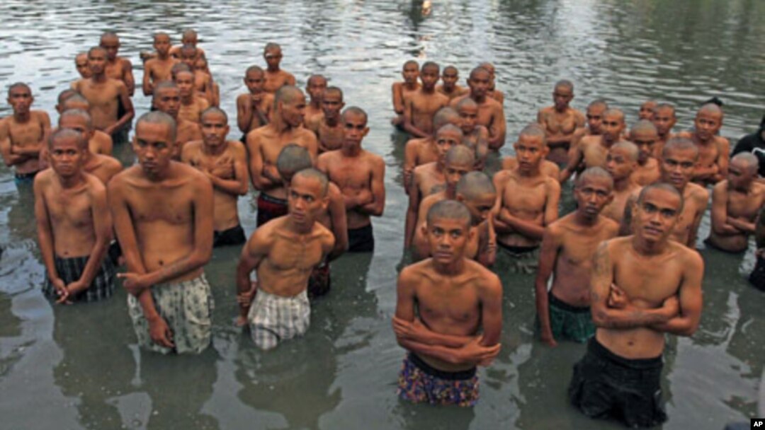 Youths stand in the pond located at a police school, after having their heads shaved by the police, in Aceh Besar of the Indonesia's Aceh province, December 13, 2011.