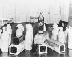 FILE - This June 12, 1924, photo shows bottles of Scotch whiskey smuggled in hollowed-out loaves of bread; location unknown.