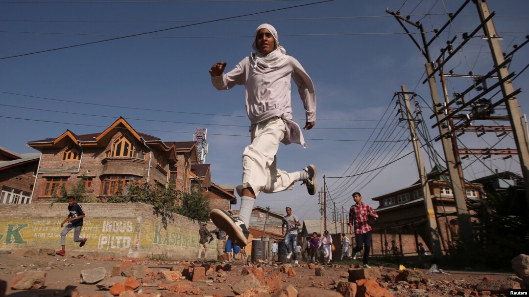 Warga Kashmir berlari mencari perlindungan ketika pasukan keamanan India (tidak tampak) menembakkan gas air mata selama bentrokan di Srinagar, Ibu Kota Kashmir, India, 6 September 2019. (Foto: Danish Ismail/Reuters)