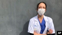 FILE - Aurelie Gouel, an ICU doctor who has recovered from COVID-19, poses during a break in her shift treating coronavirus patients at Bichat Hospital in Paris, April 7, 2020.