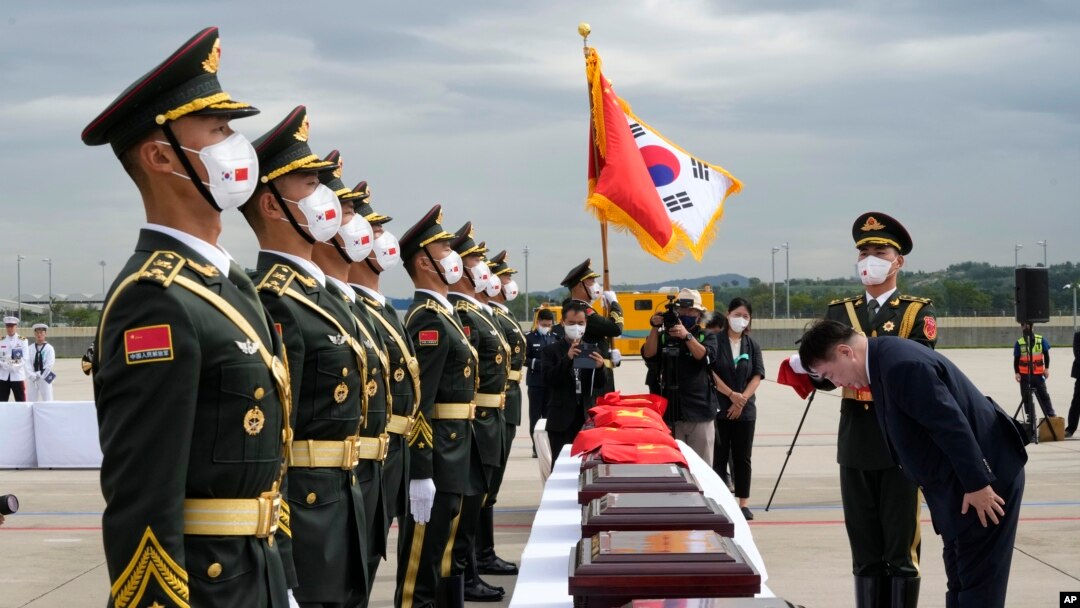 Dubes China untuk Korsel Xing Haining (kanan) memberi hormat di hadapan peti-peti yang berisi sisa jenazah tentara China, saat upacara serah terima di bandara Internasonal Incheon, Korea Selatan, 2 September 2021. (AP Photo/Ahn Young-joon, Pool)