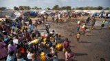 FILE - Displaced people are seen gathered around a water truck to fill containers at a United Nations compound which has become home to thousands of people displaced by fighting, in the capital Juba, South Sudan.