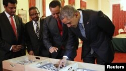 Dr. Zeresenay Alemseged Lemseged (dua dari kanan), dari California Academy of Sciences, meminta Presiden Barack Obama (kanan) untuk menyentuh fosil kerangka leluhur Lucy, manusia purba, sebelum jamuan kenegaraan di Addis Ababa (28/7). 