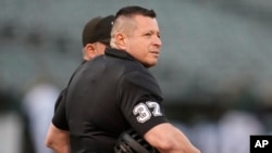 El árbitro venezolano Carlos Torres conversa con un colega antes del juego entre los Marineros de Seattle y los Atléticos de Oakland en California, el 18 de septiembre de 2024. Torres será árbitro principal del primer juego de la Serie Mundial. (ARCHIVO: AP)