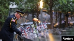 11일 9·11 테러 22주기를 맞아 은퇴 경찰관이 미국 뉴욕 시내 추모 박물관에 국기를 꽂고 있다.