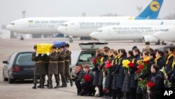 In this photo provided by the Ukrainian Presidential Press Office, honor guard carry a coffin of the one of the eleven Ukrainian victims of the Boeing 737-800 plane at Borispil international airport outside Kyiv, Jan. 19, 2020. 