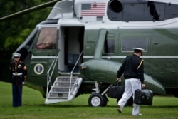 A military aid carries a suitcase with nuclear codes while accompanying President Barack Obama to Marine One of the South Lawn of the White House on May 21, 2016 in Washington.