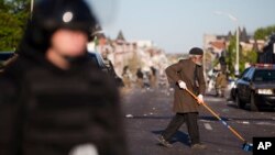 Un residente ayuda a limpiar las calles de Baltimore, luego de los pillajes del lunes por la noche.