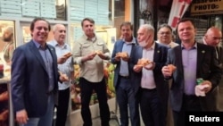 Brazil's President Jair Bolsonaro, 3rd left, eats pizza with other politicians on a street ahead of the United Nations General Assembly in New York City, September 19, 2021. (Instagram/@gilsonmachadoneto via Reuters)