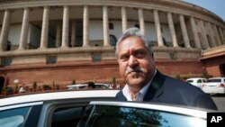 FILE - Indian business tycoon Vijay Mallya gets into his car outside the Parliament in New Delhi, India, Feb. 27, 2013.