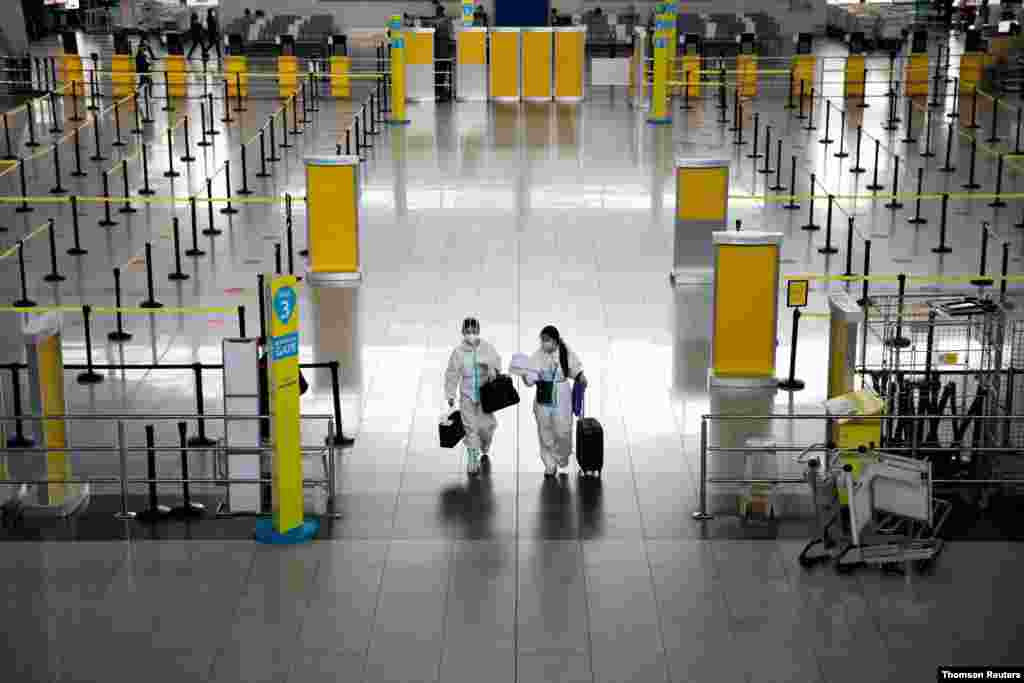 필리핀 마닐라의 니노이 아키노 국제공항에서 신종 코로나바이러스 방역복을 입은 승객들이 걸어 나오고 있다. 
