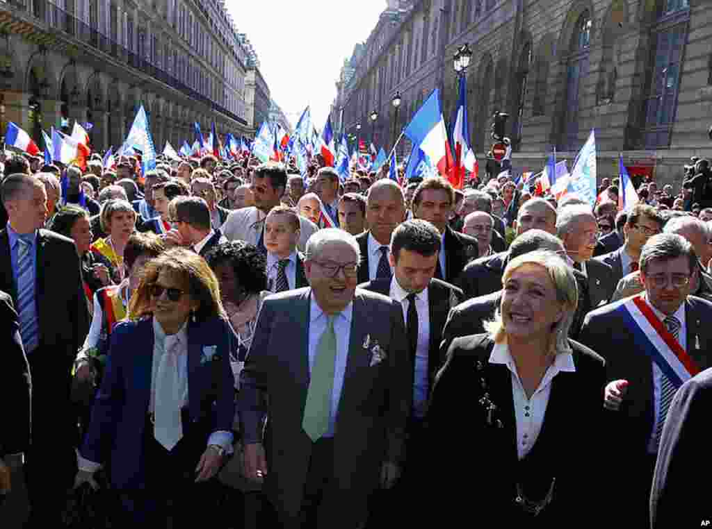 France's far-right National Front candidate for the presidential election Marine Le Pen, right, with her father Jean Marie Le Pen, walk toward the statue of Joan of Arc, during the traditional May Day march in Paris, May 1, 2012. (AP Photo)