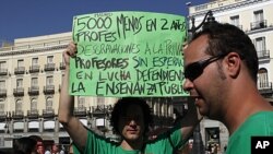 Teachers hold banners and shout slogans during their protest in central Madrid. Secondary school teachers in regions around Spain began on Tuesday a strike against spending cuts they say the government is imposing as the country fights to avoid being drag