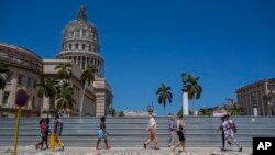 ARSIP – Orang-orang melintasi gedung Capitol, dimana renovasi tengah berjalan, di Havana, Kuba, 10 Maret 2016 (foto: AP Photo/Desmond Boyland, Arsip)