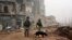 FILE - This photo made from the footage taken from Russian Defense Ministry official website on Feb. 4, 2017, claims to show Russian soldiers in a street in Aleppo, Syria. 