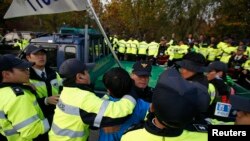South Korean policemen stop a Paju resident from rushing to an anti-North Korean civic group's vehicle near the demilitarized zone separating the two Koreas in Paju, Oct. 25, 2014. 