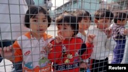 Vietnamese refugee children peek from Hong Kong's Pillar Point Refugee Centre March 9 during a visit by United Nations High Commissioner for Refugees (UNHCR) chief Sadako Ogata. 