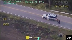 FILE - In this photo made from a Sept. 16, 2016, police video, Terence Crutcher, left, with his arms up, is pursued by police officers as he walks next to his stalled SUV moments before he was shot and killed by one of the officers in Tulsa, Okla.