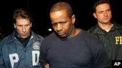 In this May 21, 2009 file photo, James Cromitie, center, is led by police officers from a federal building in New York after being arrested for plotting to bomb New York synagogues and shoot down military aircraft