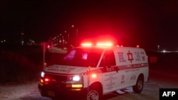 Sebuah ambulans bergerak meninggalkan lokasi serangan drone Hizbullah di dekat Kota Binyamina, Israel, pada 13 Oktober 2024. (Foto: AFP/Oren Ziv)