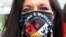 FILE - Jeannie Hovland, the deputy assistant secretary for Native American Affairs for the U.S. Department of Health and Human Services, poses with a Missing and Murdered Indigenous Women mask, in Anchorage.