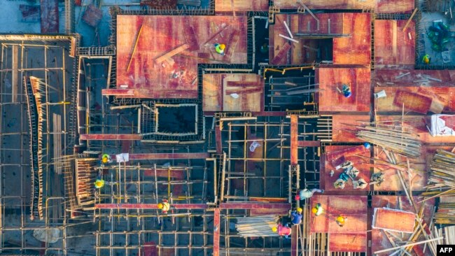 FILE - This aerial photo taken on Oct. 26, 2023, shows workers at a construction site in Huaian, in China's eastern Jiangsu province. Jiangsu authorities are encouraging workers at state-owned enterprises to take leave without pay to start their own businesses.