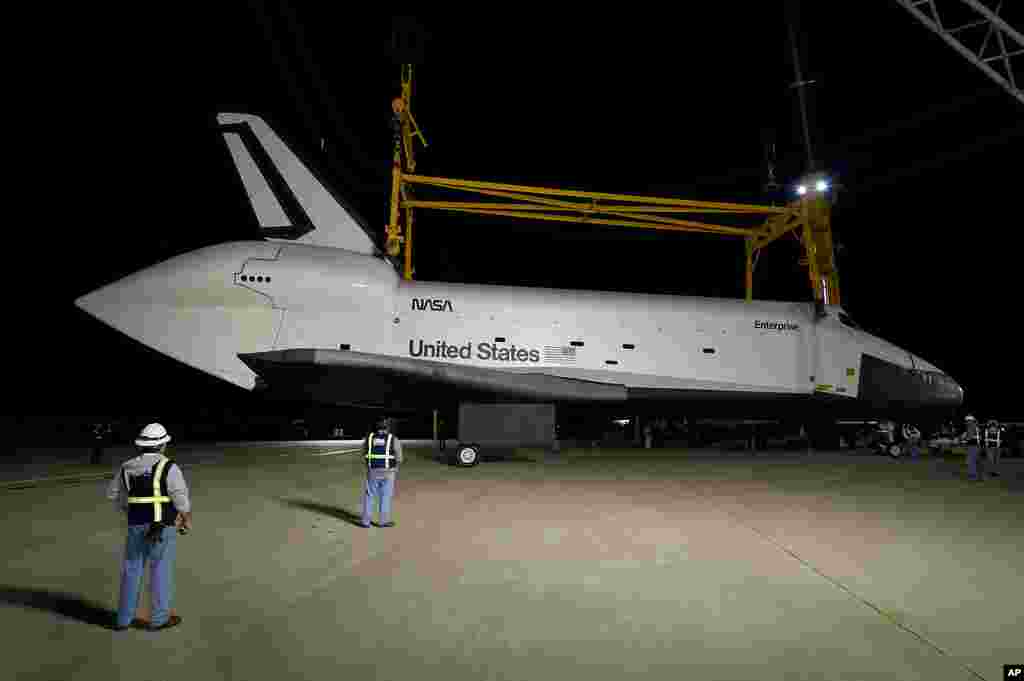 Workers lower the sling that will be used to lift Enterprise onto the NASA 747 Shuttle Carrier Aircraft at Washington Dulles International Airport, April 20, 2012. (NASA/Bill Ingalls)