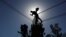 FILE - An Iraqi technician works on an electricity pole damaged during fighting between Iraqi forces and Islamic state fighters, in eastern Mosul, Iraq, April 26, 2017. 