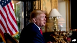 FILE - In this Dec. 24, 2019 photo, President Donald Trump speaks to members of the media following a Christmas Eve video teleconference with members of the military at his Mar-a-Lago estate in Palm Beach, Fla.