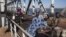 People on donkey-drawn carts cross a strategic bridge over a dam on the Niger River secured by French forces in Markala, Mali, January 18, 2013.