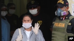 Usando mascarilla para protegerse del coronavirus, Keiko Fujimori saluda al salir de prisión por una investigación por lavado de dinero. Su sentencia fue revocada en mayo pasado.
