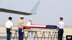 U.S. military guard of honor prepare to carry a coffin covered with U.S. national flag during repatriation ceremony at Mandalay International Airport, March 12, 2020, in Mandalay, central Myanmar.