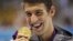 United States' Michael Phelps displays his gold medal for the men's 100-meter butterfly swimming final at the Aquatics Centre in the Olympic Park during the 2012 Summer Olympics in London, Friday, Aug. 3, 2012. (AP Photo/Matt Slocum)
