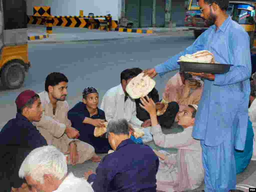 افطاری سے قبل روٹیاں تقسیم کی جا رہی ہیں