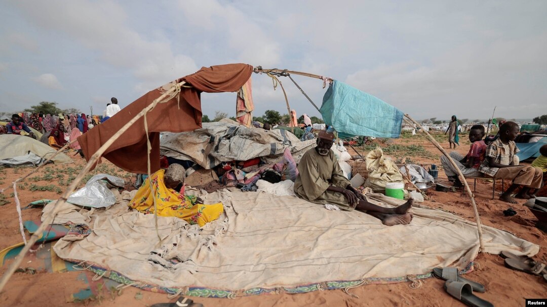 Horoun Dadoum, 80, a Sudanese man who fled the conflict in Murn in Sudan's Darfur region, sits with his wife Fatma Abdelkareem, 70, by his belongings as they arrived only yesterday in Adre, Chad, July 24, 2023.