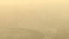 FILE - Cars drive along a highway photographed through a glass window during a dust storm amid heavy pollution in Beijing, March 10, 2023.