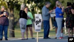 FILE - Voters stand in line to vote at an early voting polling site in San Antonio, Oct. 20, 2014.