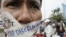 A Cambodian protester tapes his mouth shut in protest against discrimination of the Lesbian, Gay, Bisexual and Transgender (LGBT), in front of National Assembly, in Phnom Penh, file photo. 