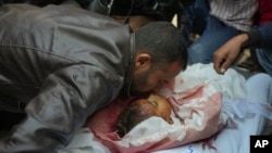 Mahmoud bin Hassan mencium jenazah salah satu anaknya sebelum prosesi pemakaman berlangsung di Khan Younis, Jalur Gaza, pada 21 November 2024. (Foto: AP/Abdel Kareem Hana)