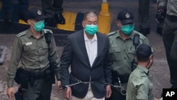 Hong Kong pro-democracy activist and media tycoon Jimmy Lai is escorted by Correctional Services officers to get on a prison van before appearing in a court, in Hong Kong, Dec. 12, 2020.