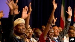 Josephine Kolea of Kenya (2nd R) raises her hand to ask a question of President Barack Obama with other attendees of the Summit of the Washington Fellowship for Young African Leaders during Obama's town hall, July 28, 2014, in Washington.